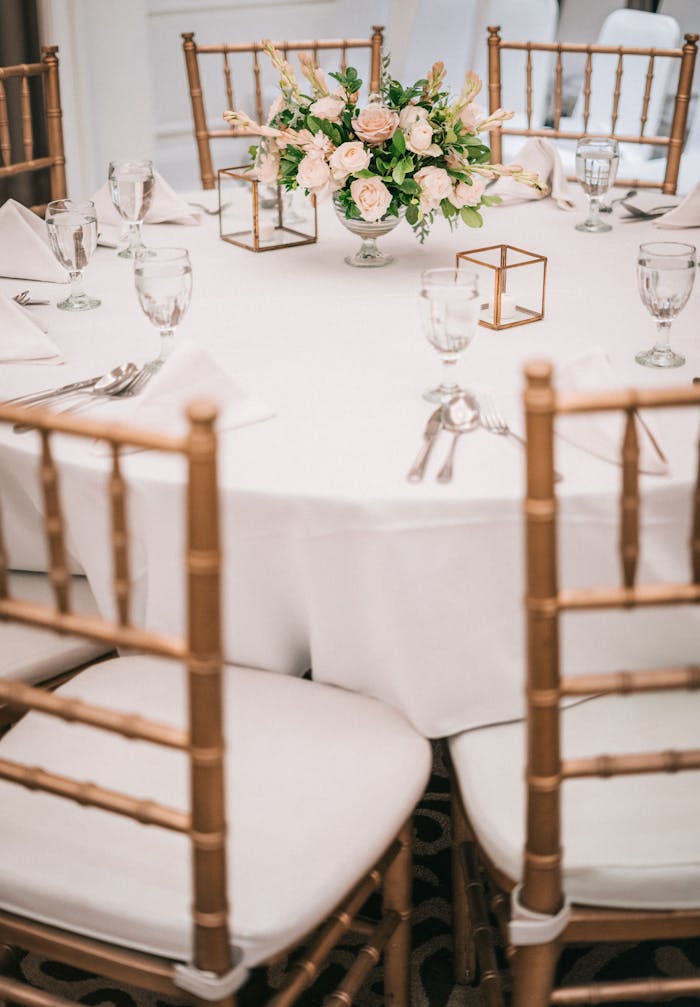 A beautifully arranged dining table with a floral centerpiece and elegant chairs indoors.